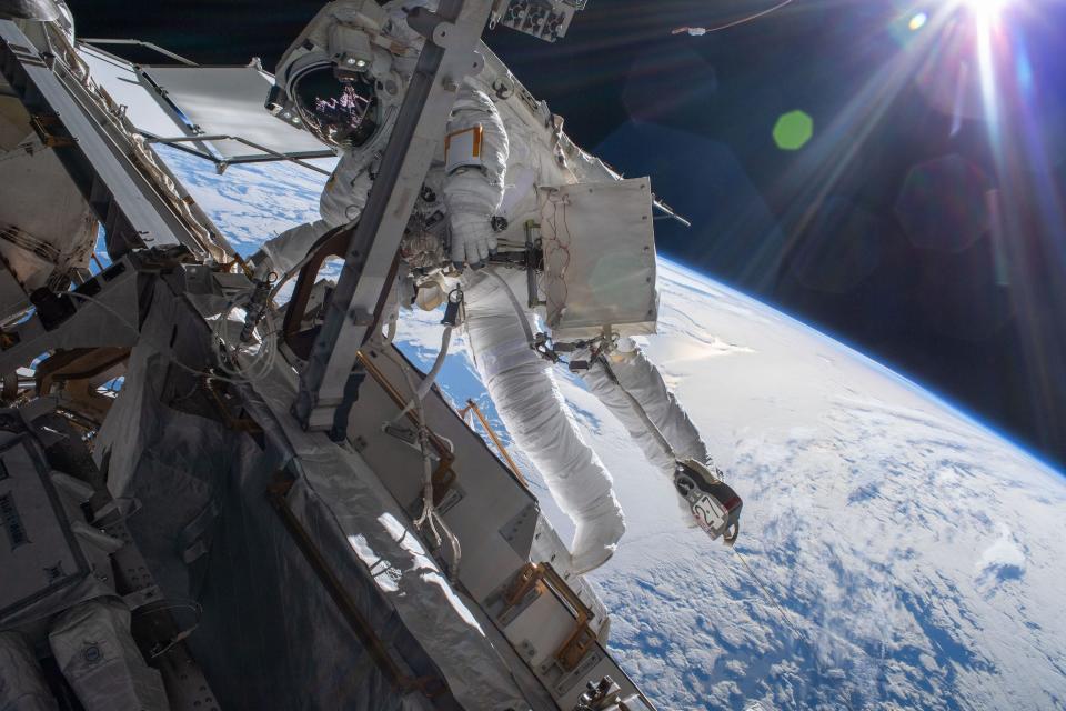 astronaut in spacesuit on spacewalk above earth