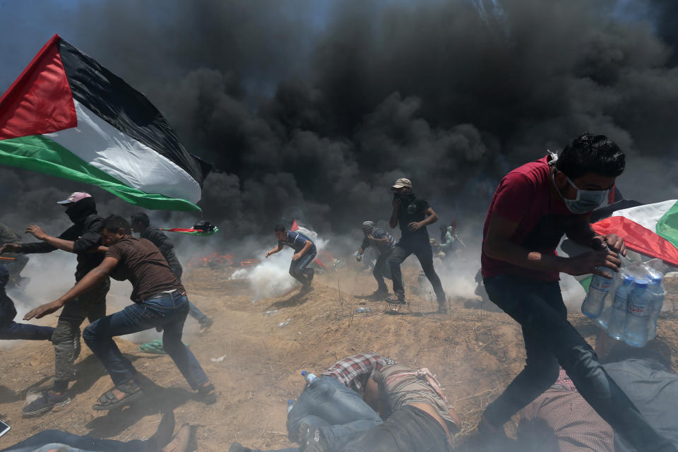 <p>Palestinian demonstrators run for cover from Israeli fire and tear gas during a protest against the U.S. Embassy’s move to Jerusalem, at the Israel-Gaza border in the southern Gaza Strip, May 14, 2018. (Photo: Ibraheem Abu Mustafa/Reuters) </p>