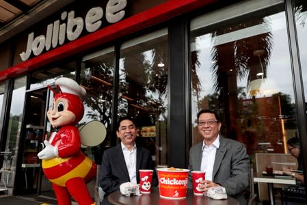 Ernesto Tanmantiong, the president and CEO of Philippine national champion Jollibee Foods Corp, and Ysmael Baysa, its CFO, pose for a picture outside a Jollibee branch in Pasig City,