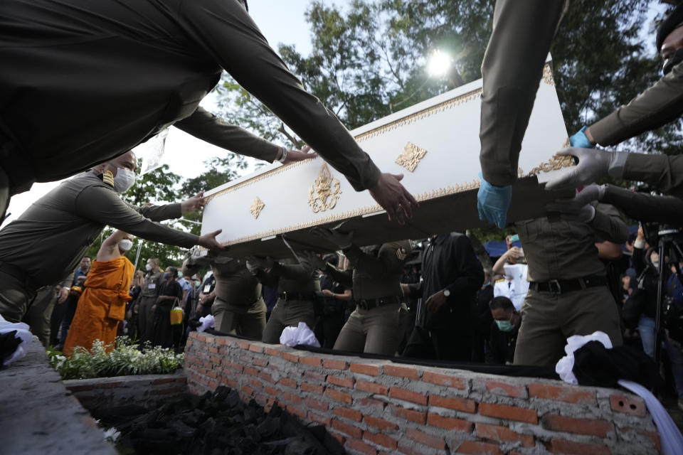 Police prepare a coffin containing a victim in the day care center attack for cremation at Wat Rat Samakee temple in Uthai Sawan, northeastern Thailand, Tuesday, Oct. 11, 2022. A former police officer burst into a day care center in northeastern Thailand on Thursday, killing dozens of preschoolers and teachers before shooting more people as he fled. (AP Photo/Sakchai Lalit)