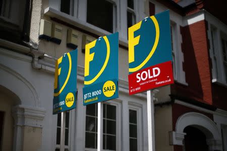 Estate agents boards are lined up outside houses in south London June 3, 2014. REUTERS/Andrew Winning