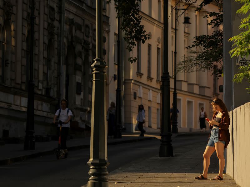 Girl uses her smarthphone on the street in Moscow