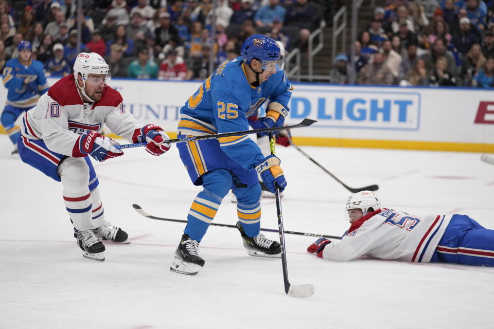 St. Louis Blues' Jordan Kyrou (25) handles the puck as Montreal Canadiens' Tanner Pearson, left, and Jordan Harris (54) defend during the second period of an NHL hockey game Saturday, Nov. 4, 2023, in St. Louis. (AP Photo/Jeff Roberson)