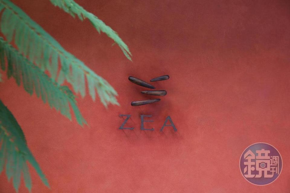 磚紅色大門上，ZEA四個點的LOGO代表著炭火、石頭、玉米、可可、辣椒、橄欖葉等拉丁美洲文化不規則的意像。