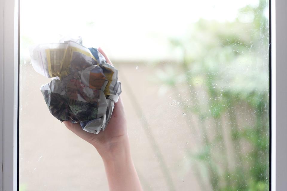 Befreien Sie den Gummi am Abzieher regelmäßig vom Dreckwasser und trocknen Sie die Ränder des Fensters mit einem weiteren Tuch. Alternativ kann statt eines Fensterabziehers auch ein altes Hausmittel zum Aufsaugen des überflüssigen Wassers benutzt werden, das obendrein fusselfrei ist: Zeitungspapier. (Bild: iStock/Pradit_Ph)