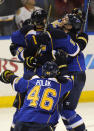 St. Louis Blues' Barret Jackman (5) is congratulated by teammates Adam Cracknell, right, and Roman Polak (46), of the Czech Republic, after his game-winning goal against the Chicago Blackhawks during overtime in Game 2 of a first-round NHL hockey playoff series, Saturday, April 19, 2014, in St. Louis. (AP Photo/Bill Boyce)