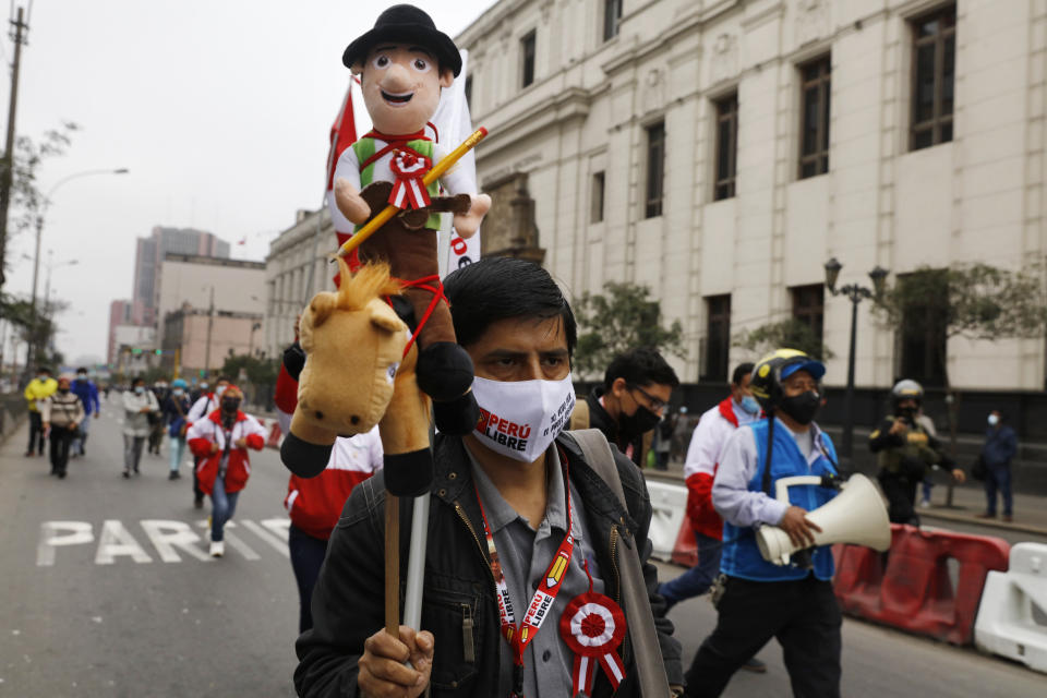 A supporter of President-elect Pedro Castillo carries a doll in his likeness on his Inauguration Day in Lima, Peru, Wednesday, July 28, 2021. (AP Photo/Guadalupe Pardo)