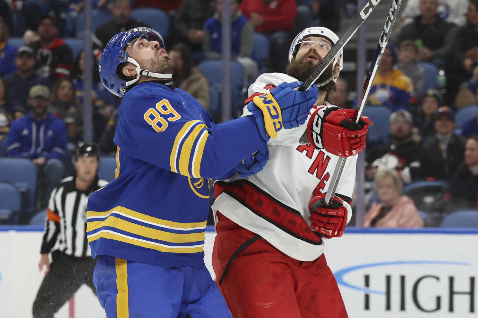 Buffalo Sabres right wing Alex Tuch (89) and Carolina Hurricanes defenseman Brent Burns (8) look for a loose puck during the first period of an NHL hockey game, Sunday, Feb. 25, 2024, in Buffalo, N.Y. (AP Photo/Jeffrey T. Barnes)