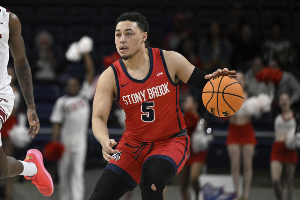 Stony Brook guard Aaron Clarke (5) handles the ball during the first half of an NCAA college basketball game in the championship of the Coastal Athletic Association conference tournament, Tuesday, March 12, 2024, in Washington. (AP Photo/Terrance Williams)