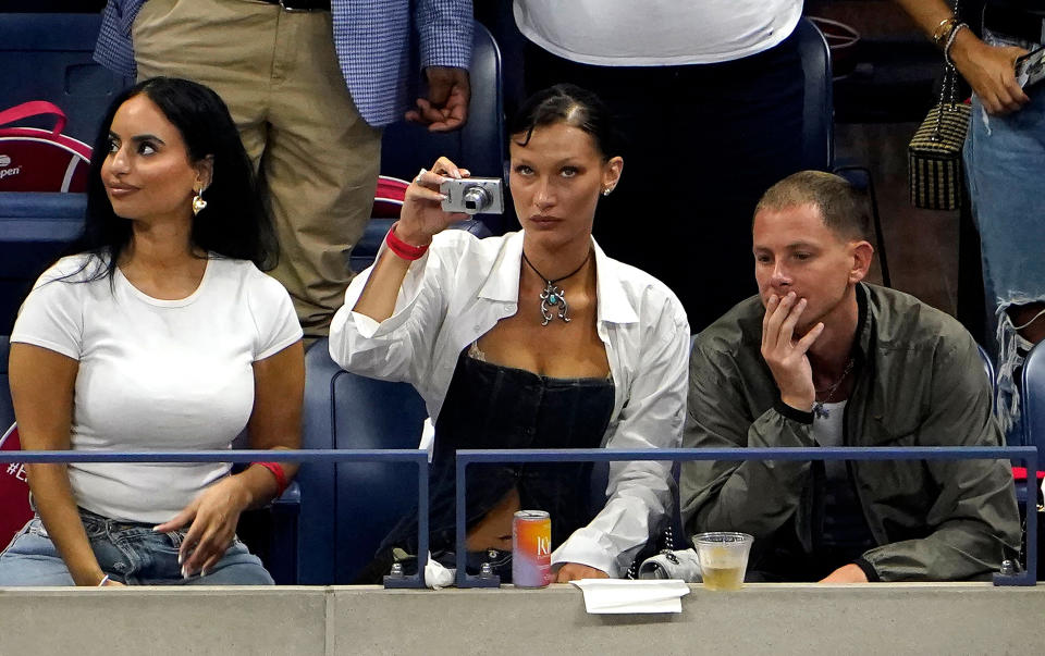 Bella Hadid (center) takes out her camera during Serena Williams' first-round match against Danka Kovinic. (Timothy A. Clary / AFP - Getty Images)