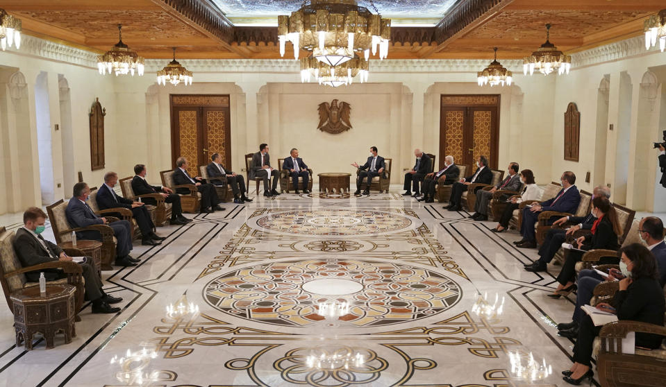 In this photo released on the official Facebook page of the Syrian Presidency, Syrian President Bashar Assad, center right, wearing a mask to help prevent the spread of the coronavirus, meets with Deputy Prime Minister Yuri Borisov, center left, and Russian Foreign Minister Sergey Lavrov, in Damascus, Syria, Monday, Sept. 7, 2020. (Syrian Presidency via Facebook)