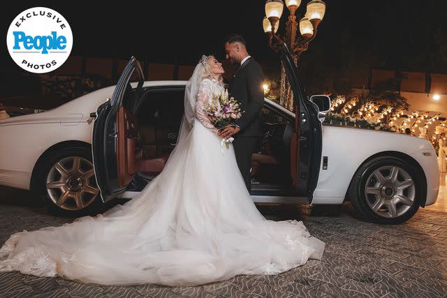 <p>Anas Abu Jaber</p> Tigerlily Taylor and Adnan Abdelfattah pose by a car at their September 2023 wedding