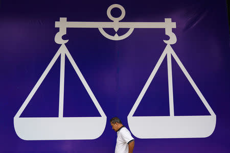 A manwalks past a banner of the Barisan Nasional party in Kuala Lumpur, Malaysia, May 7, 2018. REUTERS/Athit Perawongmetha