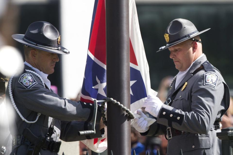 An honor guard from the South Carolina Highway patrol lowers the Confederate battle flag.