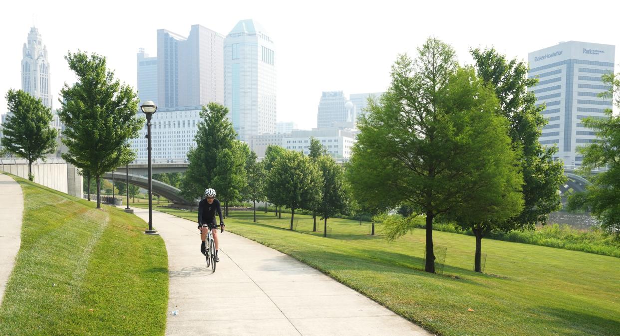 A bicyclist rides through Genoa Park along the Scioto River on June 7, 2023.