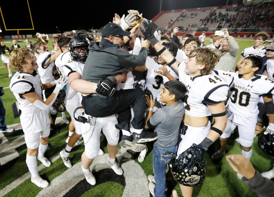 Canadian head coach Chris Koetting gets a boost up with the trophy after the Wildcats secured a 45-10 win over Wall in a Region I-3A Division II quarterfinal game, Friday, Dec. 2, 2022, at First United Park in Woodrow, Texas.