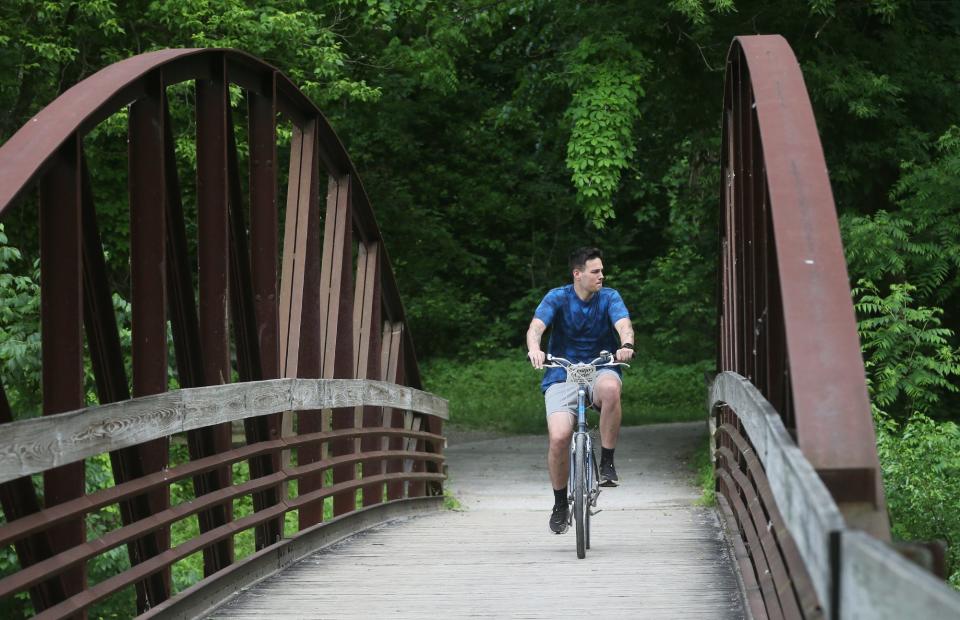 A bicyclist rides over the Cuyahoga River on the Ohio u0026 Erie Canal Towpath Trail near the Lock 29 Trailhead in Cuyahoga Valley National Park.