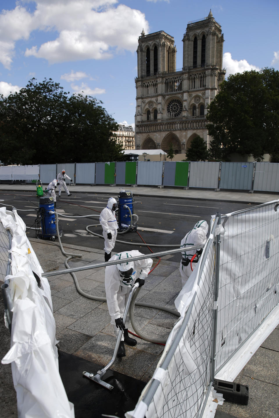 Workers clean the area in front of Notre Dame cathedral, Monday, Aug. 19, 2019 in Paris. Specialists shoring up fire-damaged Notre Dame Cathedral were returning to the Paris site on Monday for the first time in nearly a month, this time wearing disposable underwear and other protective gear after a delay prompted by fears of lead contamination. (AP Photo/Francois Mori)