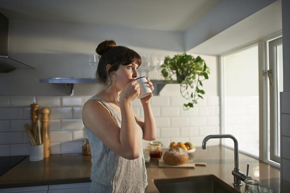 woman drinking from mug in zero waste kitchen