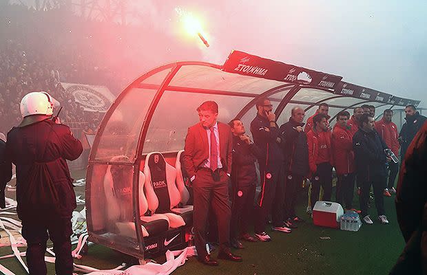 Olympiacos coach Michel narrowly avoids being hit by a flare. Source: AAP