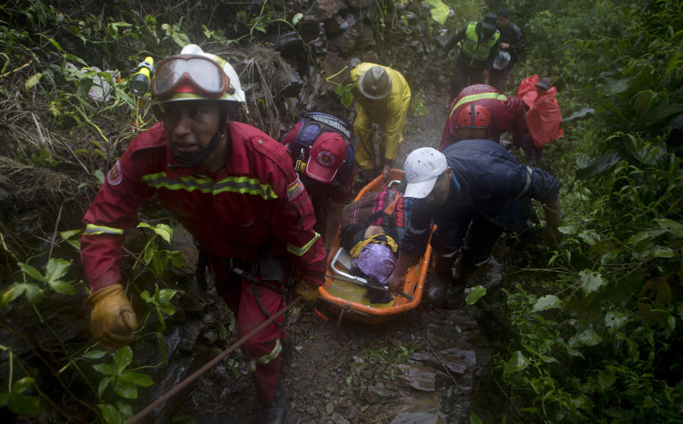 Firefighters recover the body of a victim after a mudslide on the outskirts of El Choro, Bolivia, Saturday, Feb. 2, 2019. According to police, at least five people died and others were injured after vehicles were dragged Saturday by a mudslide on a mountainous road in the north of La Paz. (AP Photo/Juan Karita)