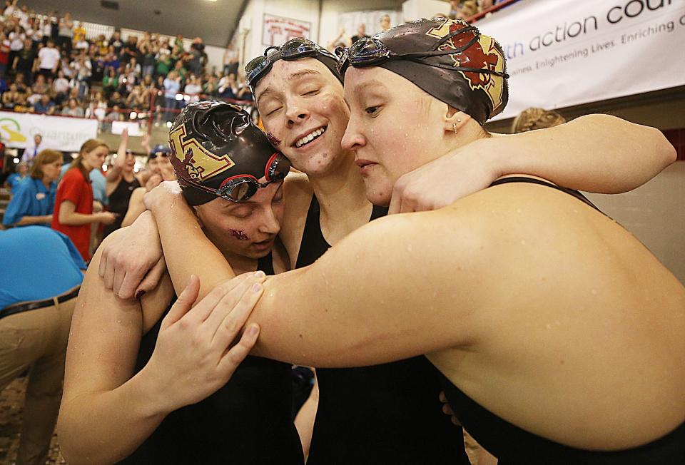 New Albany's Marisa Downs, Carly Meeting and Ashlyn Morr hug after they along with teammate Ava Lachey won the division I state title in the 400 yard freestyle relay at C.T. Branin Natatorium on Feb. 26.  