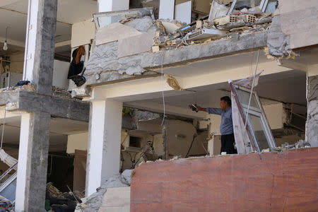 A man gestures inside a damaged building following an earthquake in Sarpol-e Zahab county in Kermanshah, Iran. REUTERS/Tasnim News Agency