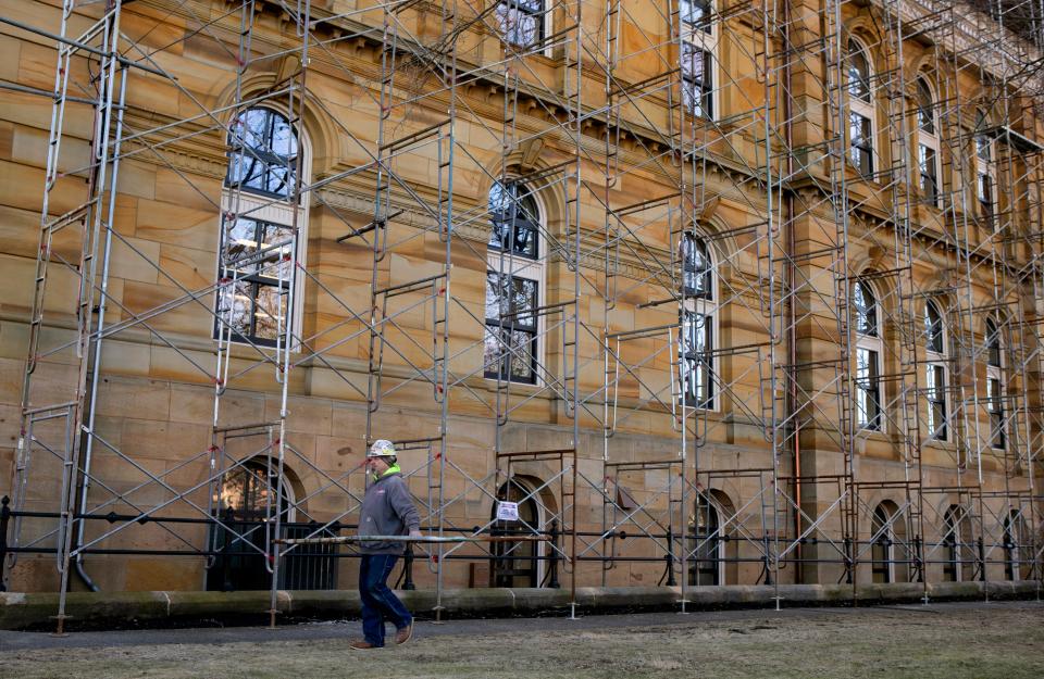A construction worker carries a piece of scaffolding to assemble as scaffolding is erected all around the Fairfield County Courthouse during construction on Feb. 6, 2024, in Lancaster, Ohio.