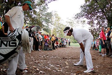 Bubba Watson and his caddie look at a shot from the rough on the second sudden death playoff hole on the 10th