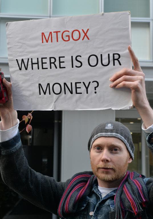 Bitcoin trader Kolin Burges from Britain holds up a placard to protest against Tokyo-based bitcoin changer MtGox in front of the company's office in Tokyo on February 26, 2014