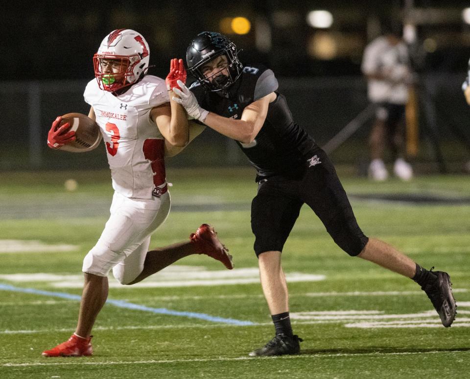 Jayden Mixon of Immokalee is shoved out of bounds by Cayden Daugherty of Gulf Coast during the district championship game at Gulf Coast High on Friday night, October 27, 2023. Photo by Darron R. Silva