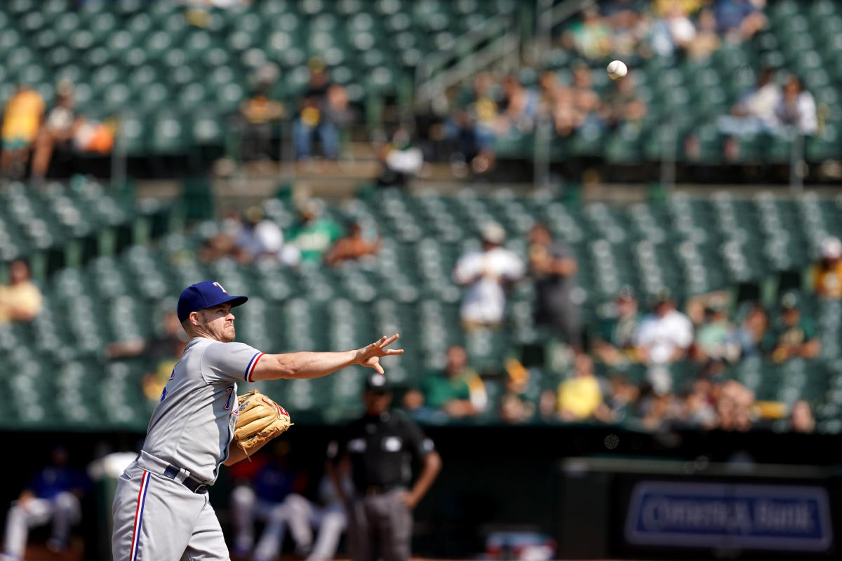 Texas Rangers third baseman Brock Holt (16) blows a bubble during