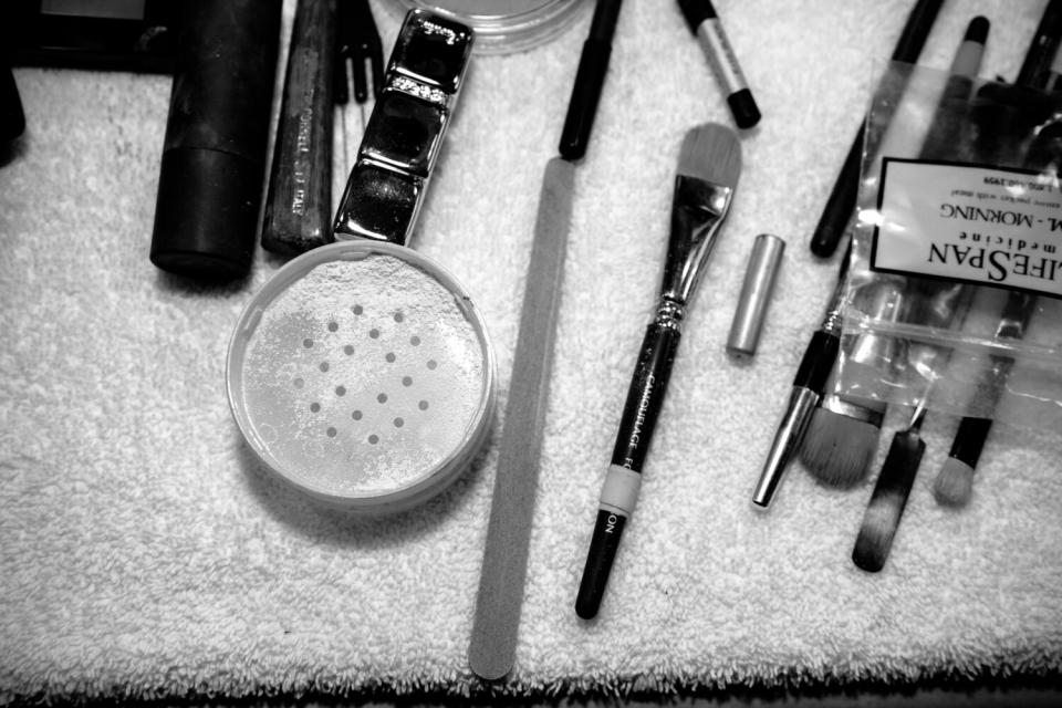 Makeup brushes and makeup laid out on a towel.