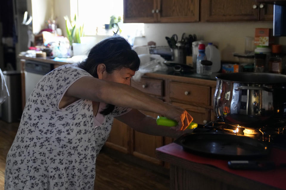 Celia Magdaleno turns on her gas stove to boil water before giving her husband a bath, following an earthquake in Rio Dell, Calif., Wednesday, Dec. 21, 2022. Magdaleno's husband is undergoing dialysis treatment and said is crucial for him to be clean before receiving treatment to avoid infections. (AP Photo/Godofredo A. Vásquez)