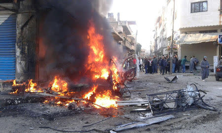 People gather at a site of a car bomb blast at the Syrian city of Latakia, Syria in this handout released by SANA on January 22, 2019 .SANA/Handout via REUTERS