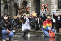 Demonstrators hold placards during a Black Lives Matter rally in Parliament Square in London, Saturday, June 6, 2020, as people protest against the killing of George Floyd by police officers in Minneapolis, USA. Floyd, a black man, died after he was restrained by Minneapolis police while in custody on May 25 in Minnesota. (AP Photo/Alberto Pezzali)