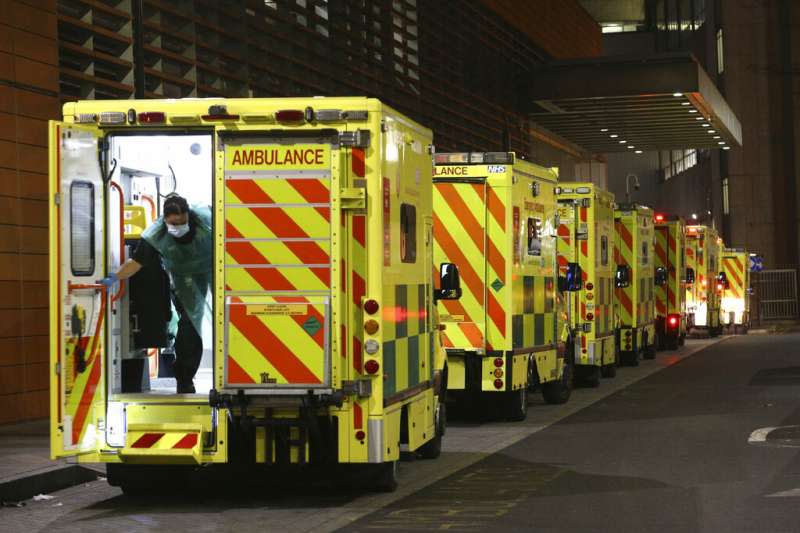 皇家倫敦醫院外停放了一整排救護車。由於英國疫情快速嚴重惡化，英國政府正在考慮宣布更嚴格的疫情對策。（美聯社）