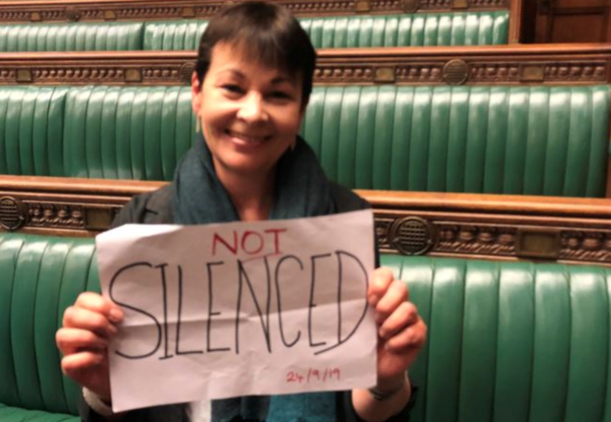 Green Party leader Caroline Lucas holds a sign reading 'not silenced' as she sits in the House of Commons on Tuesday. (PA)