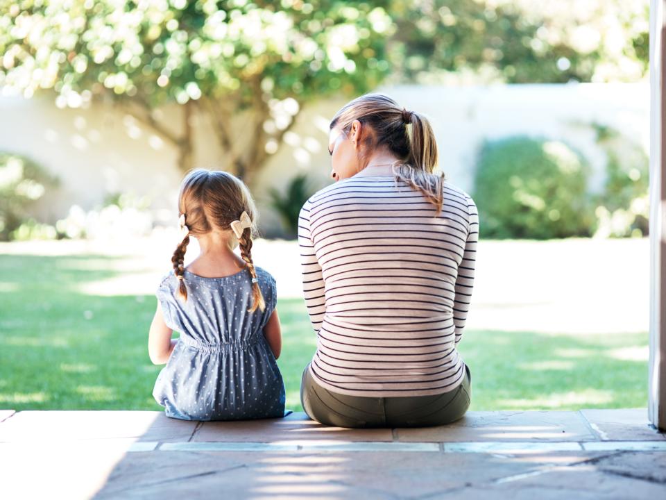 A mom sitting next to her daughter.