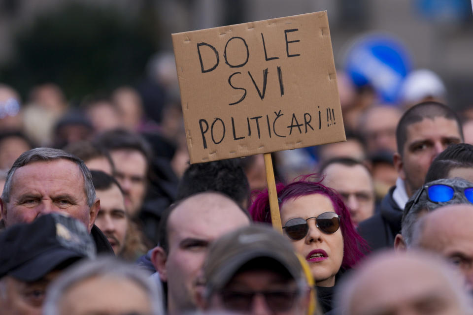 A woman holds a banner that reads in Serbian: "Down with all politicians!!!" during a rally of ProGlas initiative in Nis, Serbia, Sunday, Dec. 10, 2023. ProGlas initiative was formed by a number of prominent public figures to call the electorate to turn out to vote at the Dec. 17 elections. Serbia's President Aleksandar Vucic is pushing hard to reassert his populist party's dominance at this weekend's early parliamentary and local elections that observers say are being held in an atmosphere of intimidation and media bias. (AP Photo/Darko Vojinovic)