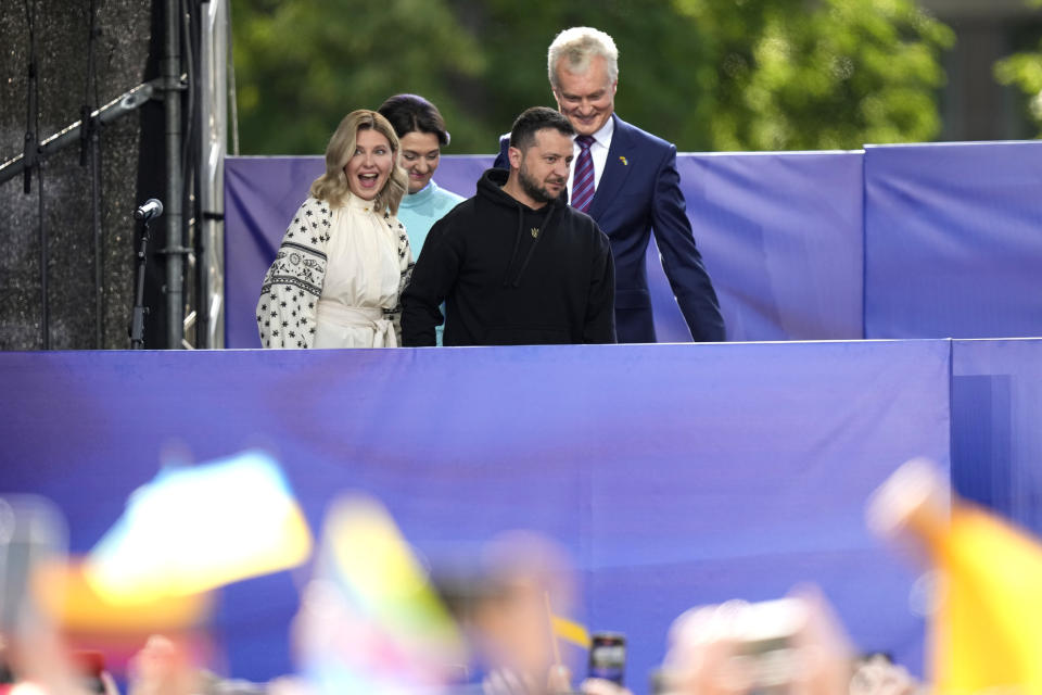 Lithuania's President Gitanas Nauseda and his wife Diana Nauseda, right, walks with Ukraine's President Volodymyr Zelenskyy and his wife Olena Zelenska prior to addressesing the public during an event on the sidelines of a NATO summit in Vilnius, Lithuania, Tuesday, July 11, 2023. Ukrainian President Volodymyr Zelenskyy on Tuesday blasted as "absurd" the absence of a timetable for his country's membership in NATO, injecting harsh criticism into a gathering of the alliance's leaders that was intended to showcase solidarity in the face of Russian aggression. (AP Photo/Pavel Golovkin)