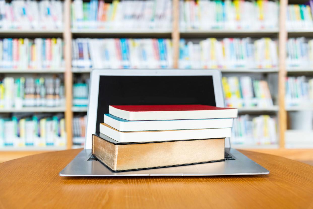 textbooks on top of laptop in school library