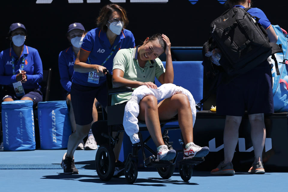 Harmony Tan of France is taken from the court in a wheelchair during her second round match against Elina Svitolina of Ukraine at the Australian Open tennis championships in Melbourne, Australia, Wednesday, Jan. 19, 2022. (AP Photo/Hamish Blair)