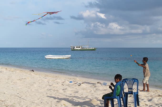 Some of the local boys fly kites on the shore. Photo: Roderick Eime