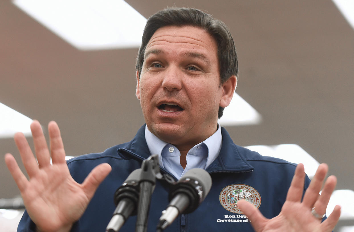 Florida Gov. Ron DeSantis stands at a microphone as he speaks at a press conference.