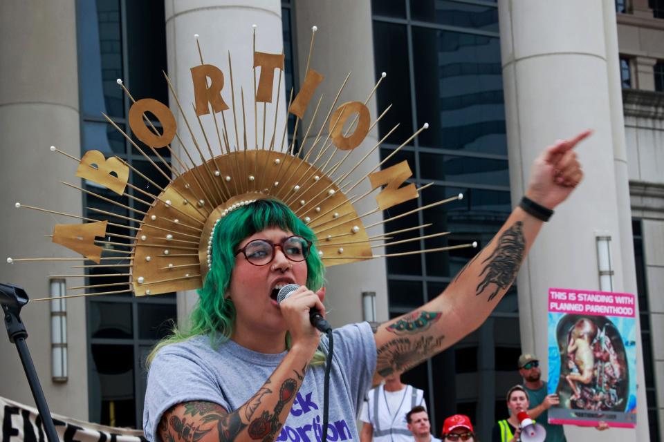 Alyx Carrasquel a coordinator for Florida Access Network delivers a message as a counter-protestor hangs around Friday, June 24, 2022, in downtown Jacksonville. Hundreds came out express disappointment in today's Supreme Court 5-4 overturning the 1973 Roe vs. Wade case. The decision eliminated the constitutional right to an abortion. The crowd protested with signs and chants outside the Duval County Courthouse, hosted speakers, and capped off the night with a march downtown.