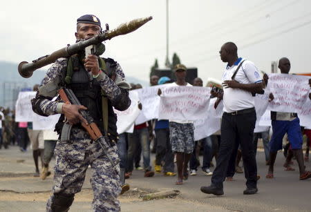 A Burundian soldier walks infront of residents during a demonstration against the Rwandan government in Burundi's capital Bujumbura, February 20, 2016. REUTERS/Evrard Ngendakumana