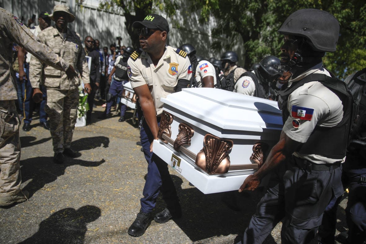 Police carry the coffin of one of three fellow officers who were killed in the line of duty for the wake at the Police Academy in Port-au-Prince, Haiti, Tuesday, Jan. 31, 2023. The officers were killed in an ambush by gang members in the capital on Jan. 20. (AP Photo/Odelyn Joseph)