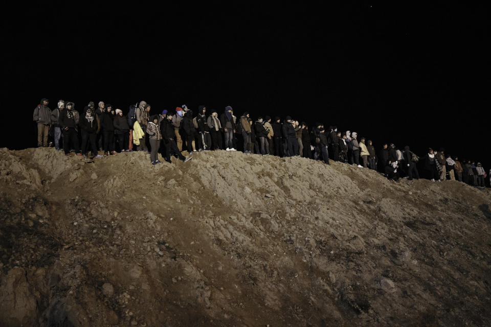 Migrants stand by the border fence as they attempt to get into the U.S. side to San Diego, Calif., from Tijuana, Mexico, Tuesday, Jan. 1, 2019. Discouraged by the long wait to apply for asylum through official ports of entry, many migrants from recent caravans are choosing to cross the U.S. border wall and hand themselves in to border patrol agents. (AP Photo/Daniel Ochoa de Olza)