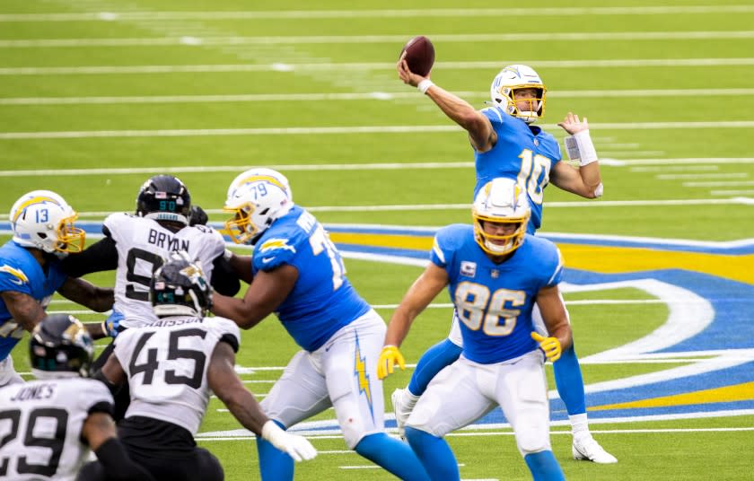 INGLEWOOD, CA - OCTOBER 25: Chargers quarterback Justin Herbert, right, throws a 70-yard touchdown pass to wide receiver Jalen Guyton in the third quarter against the Jaguars at an empty SoFi Stadium on Sunday, Oct. 25, 2020 in Inglewood, CA. The rookie quarterback finished 27 of 43 for 347 yards and three touchdowns. He also led the Chargers in rushing with 66 yards on nine carries and scored a touchdown on the ground. Herbert's 66 yards set a franchise record for rushing yards by a quarterback. (Allen J. Schaben / Los Angeles Times)